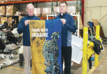 							                                Father Myronyuk presented Atty. Conaboy with a flag signed by injured Ukrainian soldiers as a symbol of gratitude for the generous donation. Standing from left: Atty. Bill Conaboy, President & CEO, Allied Services; Father Myron Myronyuk, Pastor of St.Vladimir Ukrainian Catholic Church 					